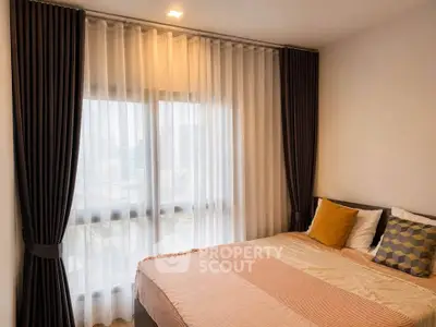 Cozy bedroom with large window and elegant curtains in modern apartment