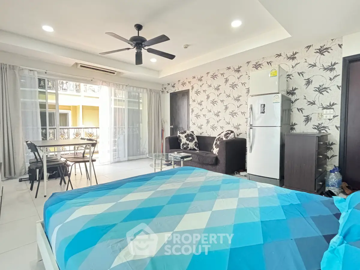 Spacious studio apartment with modern decor, featuring a cozy living area, dining space, and a well-equipped kitchen.