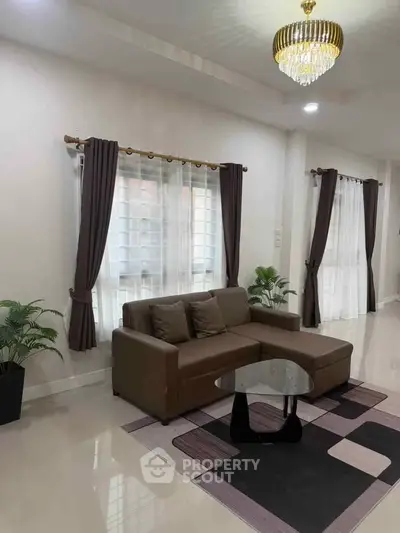 Elegant living room with modern sofa, chic chandelier, and stylish decor in a bright, airy space.