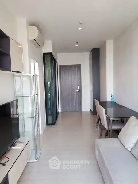 Modern living room with sleek furniture and glass display cabinet