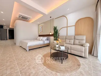 Spacious modern bedroom with cozy seating area and stylish decor