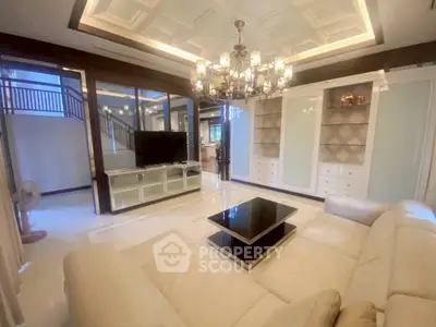 Luxurious living room with elegant chandelier and modern furnishings in a spacious home.