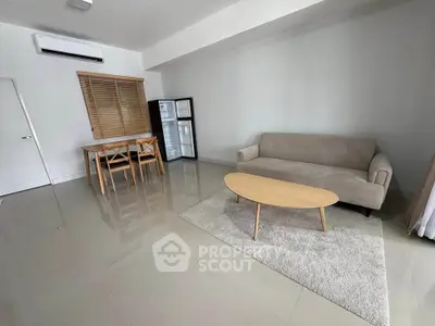 Spacious living room with modern furniture and natural light, perfect for relaxation and entertainment.