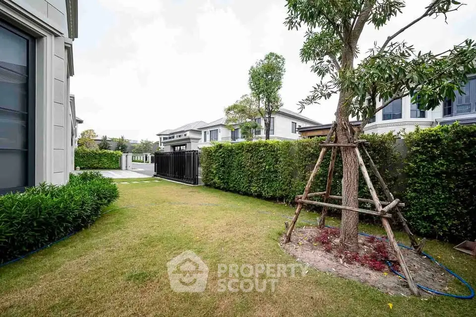 Spacious garden area with lush greenery and modern house exterior, perfect for outdoor relaxation.