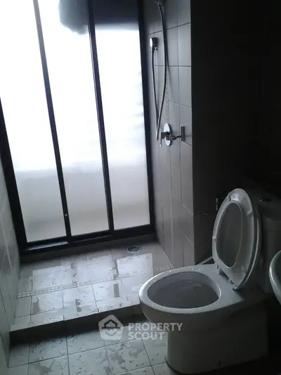 Modern bathroom with sleek shower and frosted glass window for privacy.