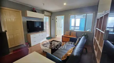 Cozy living room with modern decor and large TV, perfect for relaxation.