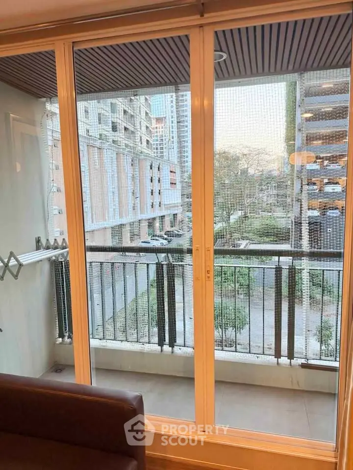 Spacious balcony with sliding glass doors offering a serene view of modern urban living.
