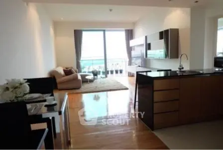 Spacious modern living room with open kitchen and large balcony view.