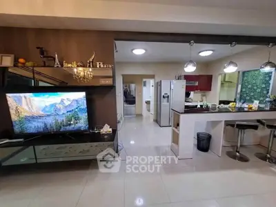 Modern open-layout living room and kitchen with sleek appliances and stylish decor.