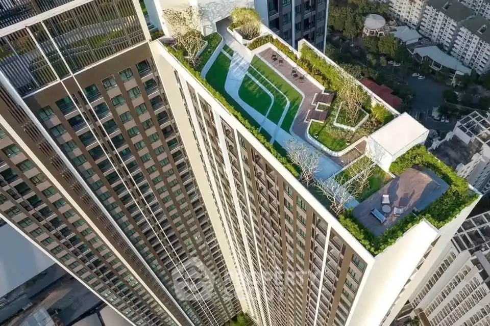 Stunning aerial view of a modern high-rise building with a lush rooftop garden and recreational area.