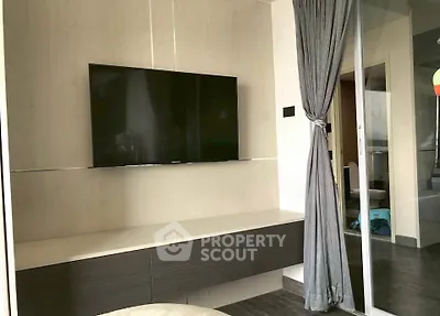 Modern living room with wall-mounted TV and elegant curtain divider
