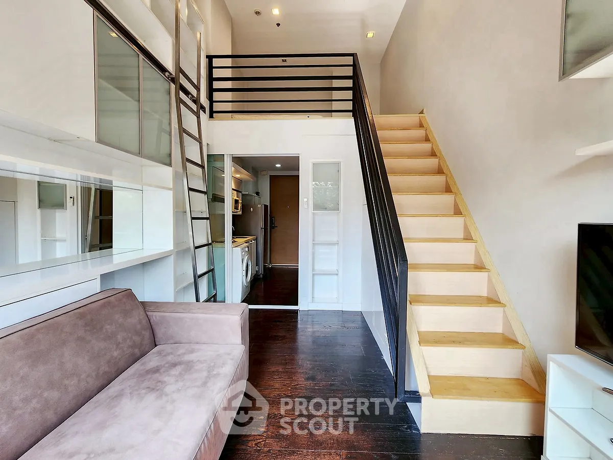 Modern loft apartment with mezzanine, sleek kitchen, and cozy living area.