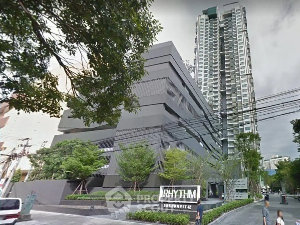 Modern high-rise condominium with lush greenery and sleek design in urban setting.