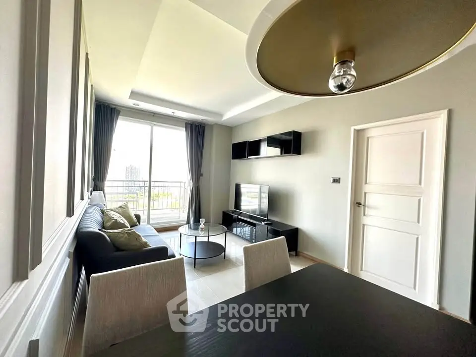 Modern living room with sleek furniture and large window offering natural light