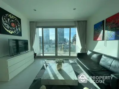 Modern living room with city view, sleek black leather sofa, and contemporary art.