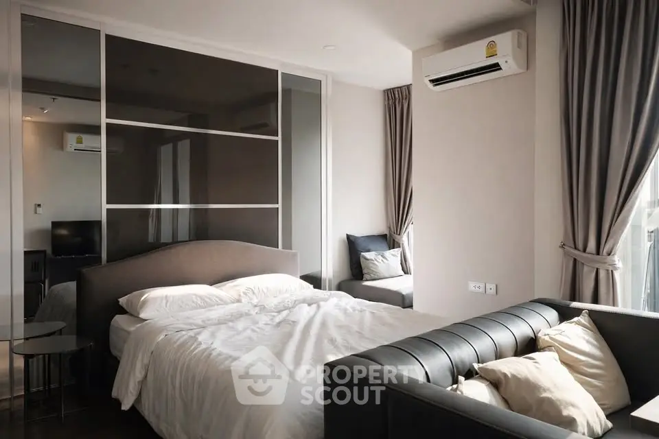 Modern bedroom with stylish decor and natural light, featuring a cozy bed and elegant furnishings.