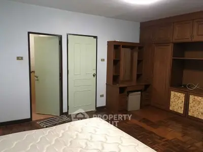 Spacious bedroom with wooden furniture and parquet flooring