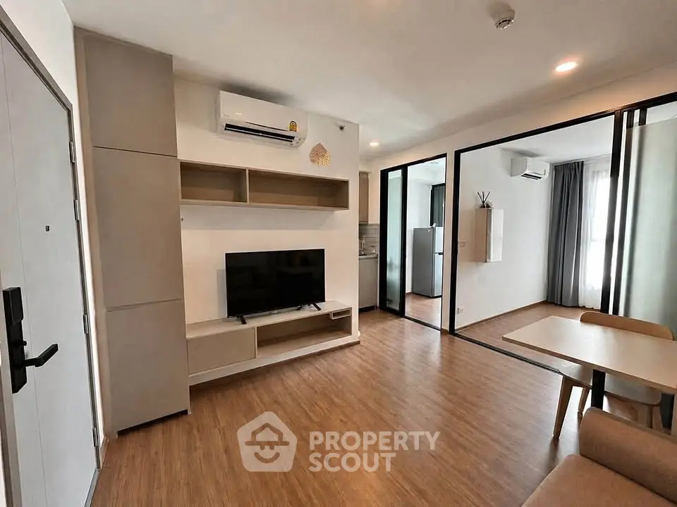 Modern living room with wooden flooring and open layout in a stylish apartment.