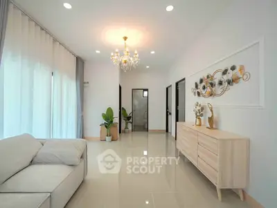 Elegant living room with chandelier, modern decor, and natural light.