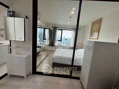 Modern bedroom with city view, mirrored closet, and sleek furnishings