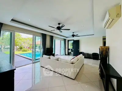 Spacious living room with pool view and modern furnishings