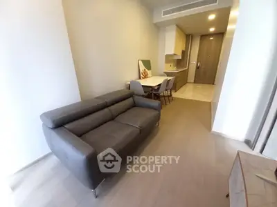 Modern living room with sleek furniture and open kitchen layout in a stylish apartment.