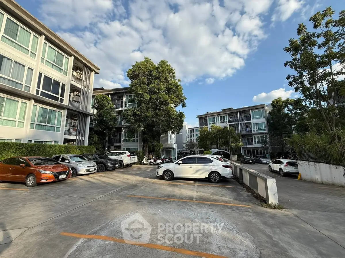 Modern apartment complex with spacious parking and lush greenery