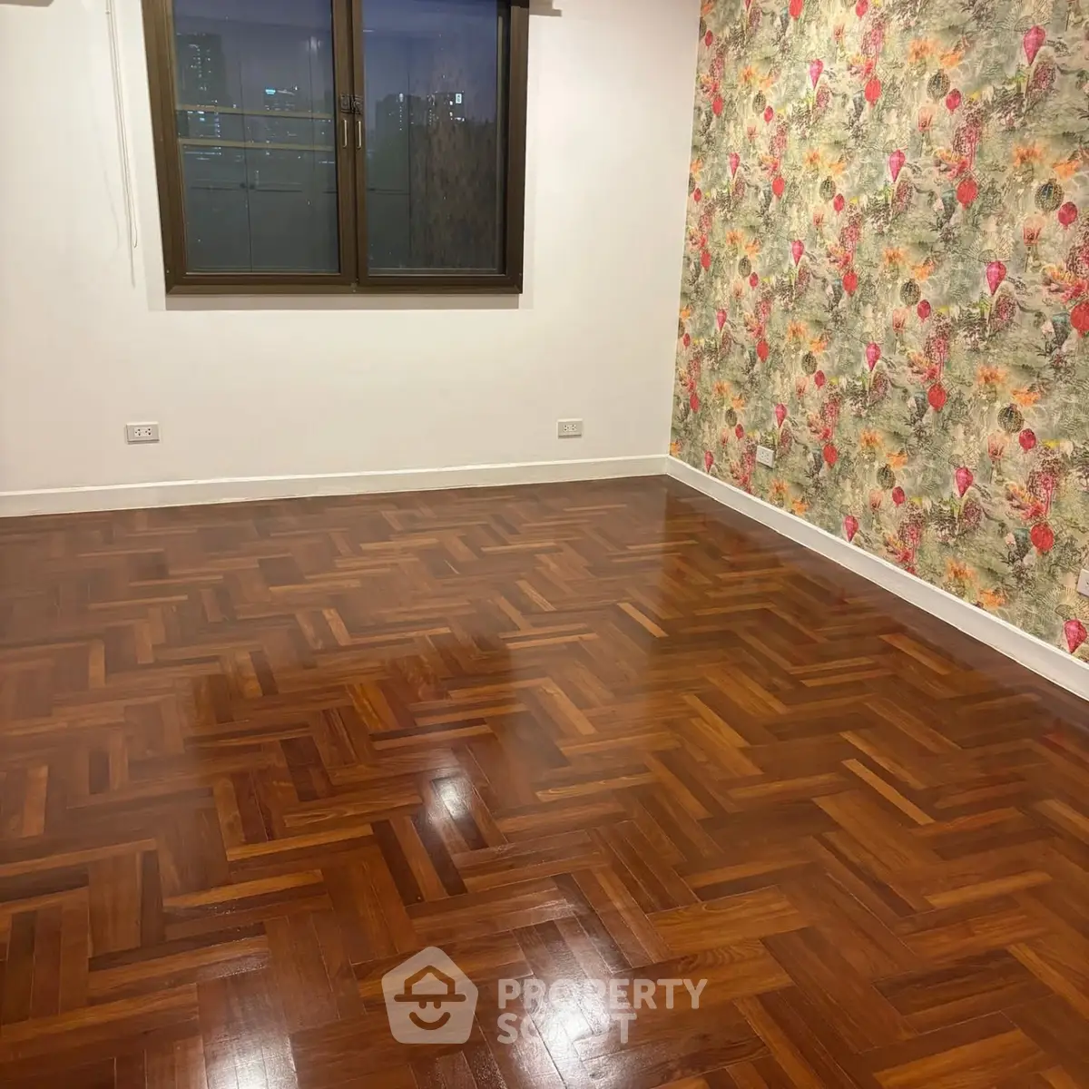 Spacious room with elegant parquet flooring and vibrant floral accent wall.