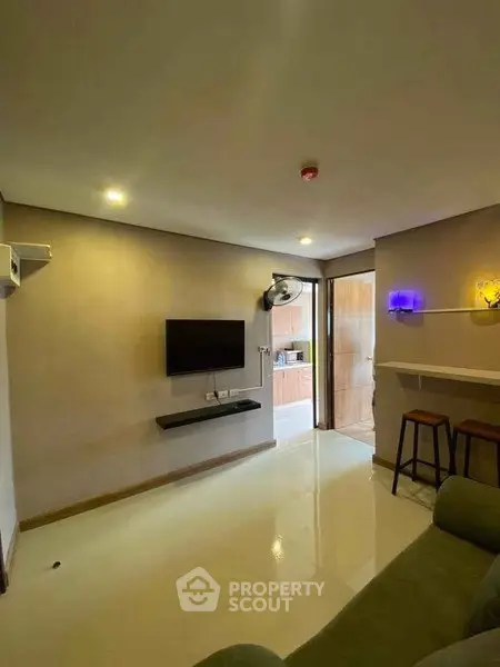 Modern living room with wall-mounted TV and bar seating, ideal for cozy gatherings.