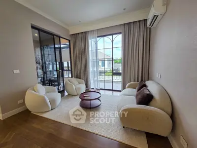 Elegant living room with plush seating and large window overlooking balcony