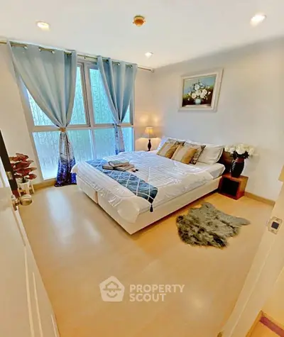 Cozy bedroom with large window and stylish decor in modern apartment