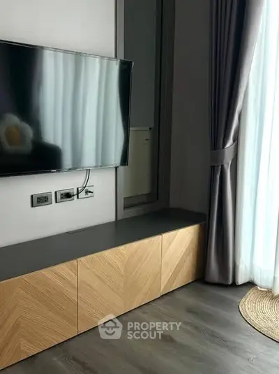 Modern living room with sleek TV setup and elegant curtains