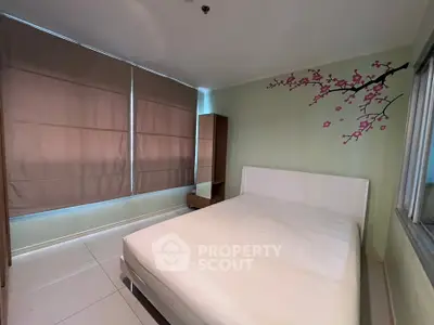 Cozy bedroom with large windows and floral wall decal, perfect for relaxation.