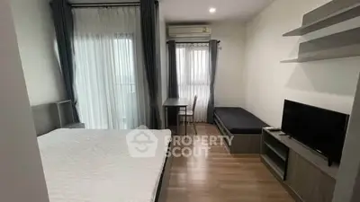 Modern bedroom with natural light, featuring a cozy bed, TV, and study area.