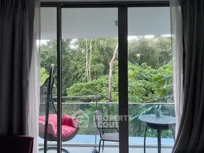Spacious balcony with lush green view and cozy seating area