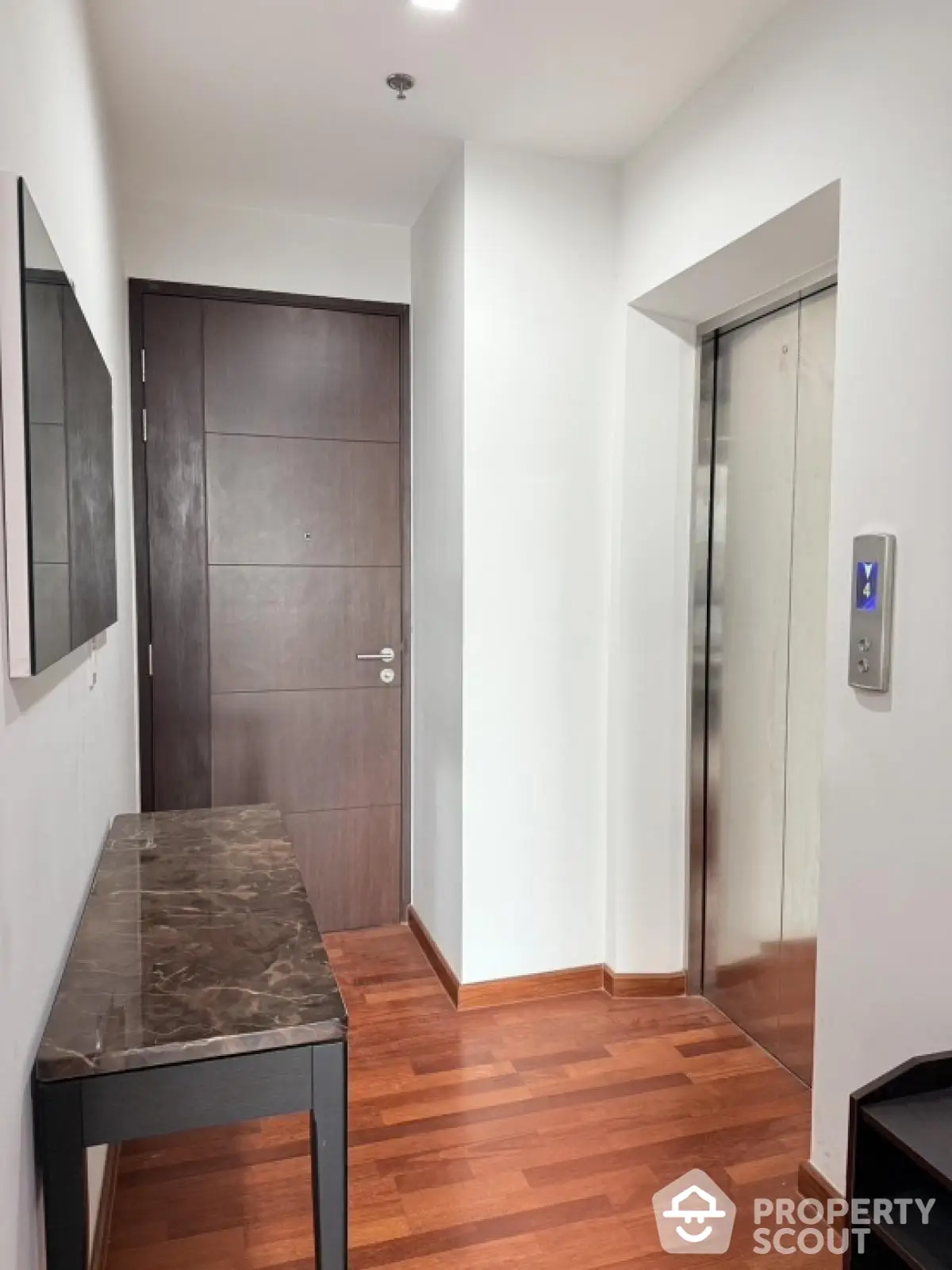 Modern apartment entrance with elevator and wooden flooring