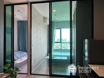 Modern apartment with glass partition and city view, featuring a cozy bedroom and stylish decor.