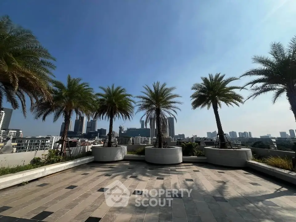 Stunning rooftop terrace with panoramic city views and lush palm trees.