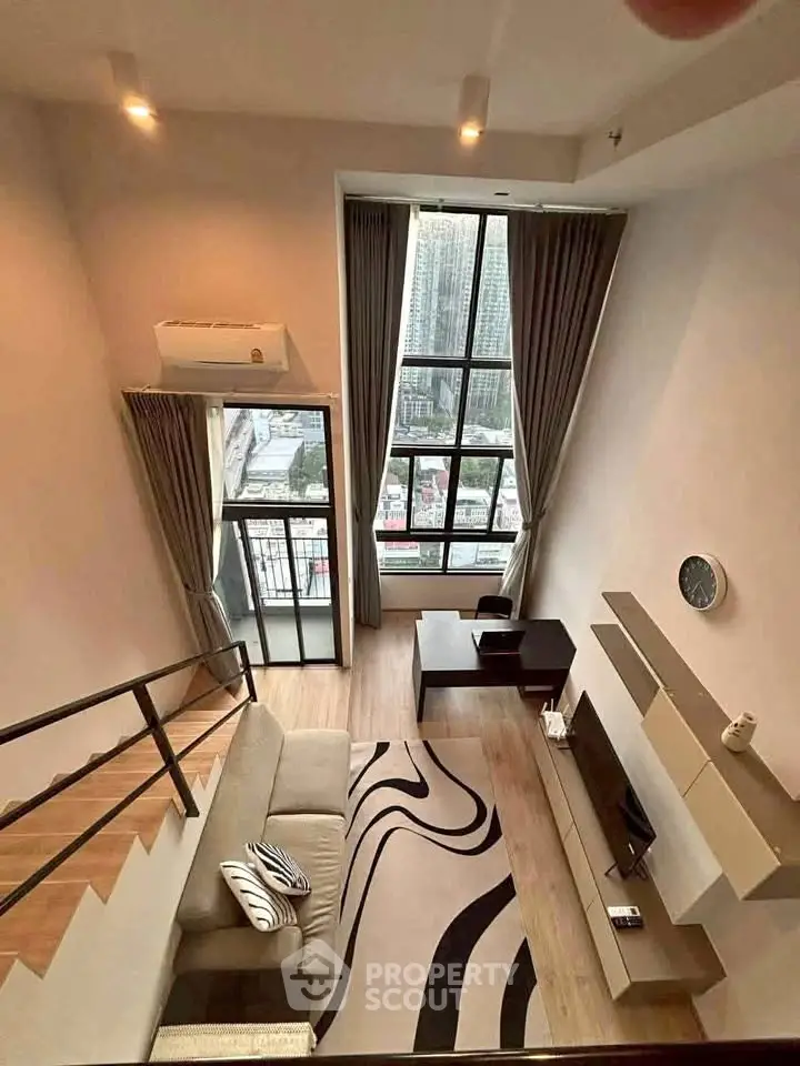 Modern loft apartment with high ceilings and large windows offering stunning city views.
