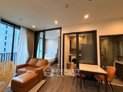 Modern open-plan living room with leather sofa and dining area in a stylish apartment.