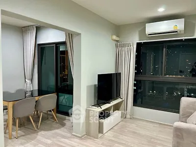 Modern living room with dining area and city view, featuring sleek furniture and air conditioning.