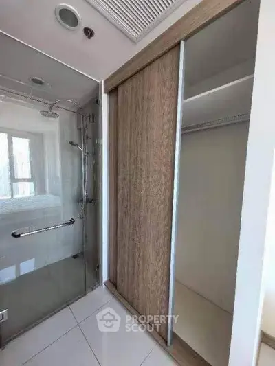 Modern bathroom with glass shower and sliding wooden closet doors