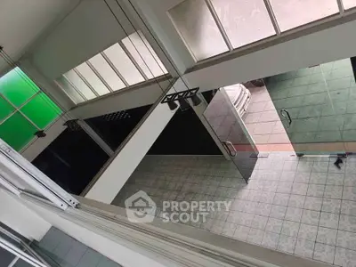 Spacious modern interior with glass doors and tiled flooring, ideal for versatile usage.