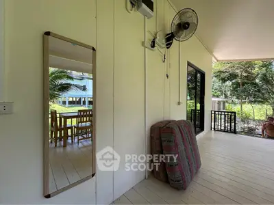 Charming outdoor patio with wooden flooring and dining set, perfect for relaxing in a serene natural setting.