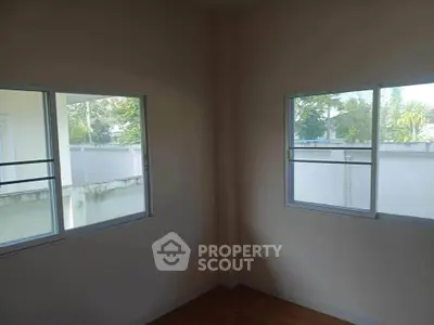 Bright corner room with two windows offering garden views