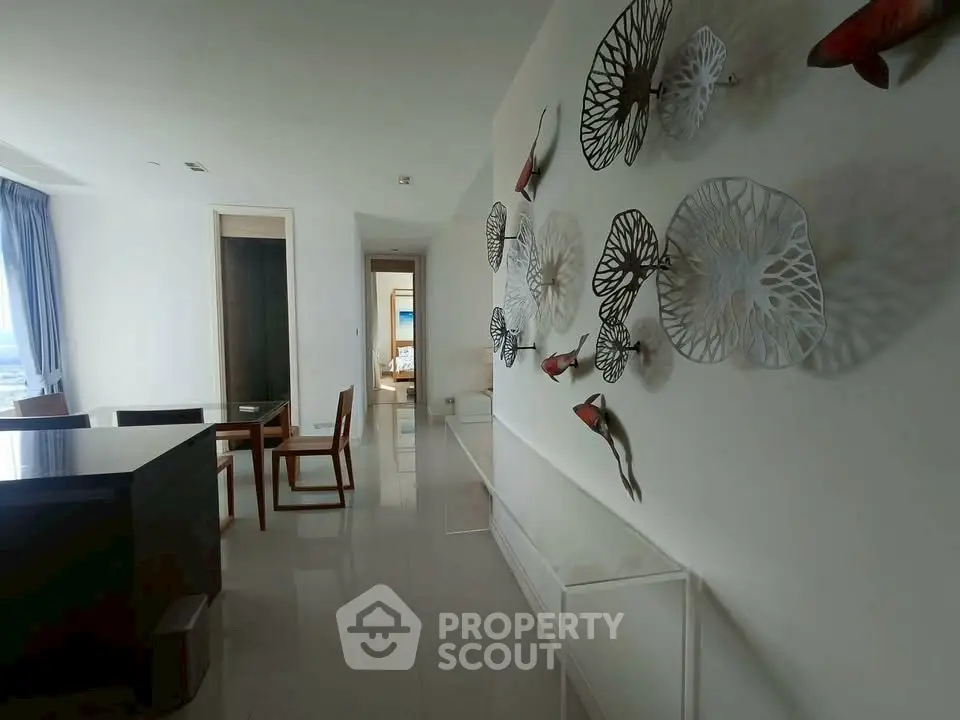 Elegant dining area with artistic wall decor and modern furniture in a spacious apartment.