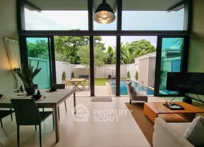 Luxurious living room with pool view, modern furniture, and expansive windows in a serene setting.