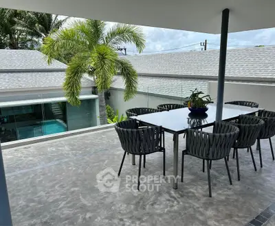 Luxurious outdoor dining area with modern furniture and pool view, perfect for entertaining in style.