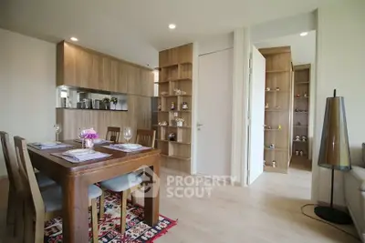 Modern dining area with wooden furniture and open kitchen layout in a stylish apartment.