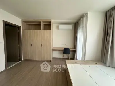 Modern bedroom with built-in wardrobe and desk, featuring sleek design and ample natural light.